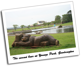 View of a carved wooden bear, boating lake, duck pond and green at Youngs Park, Goodrington